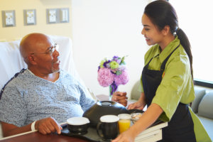 nurse serving food to an elderly man